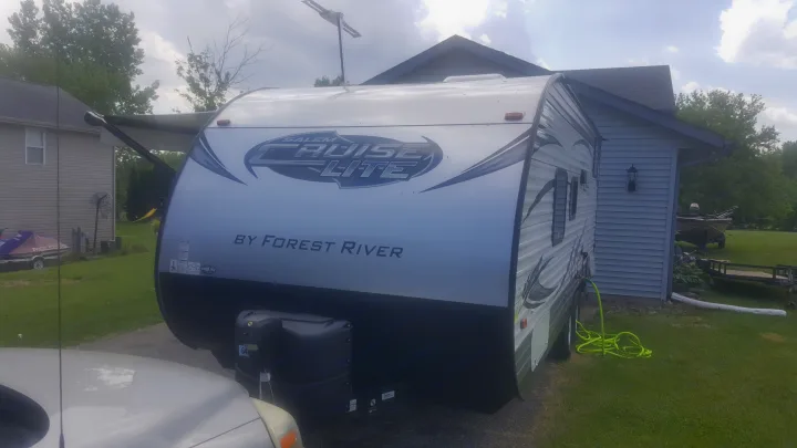 A Salem Cruise Lite by Forest River travel trailer (RV) parked with awning extended. An RV rental option for camping trips.. Forest River Salem Cruise Lite 2017