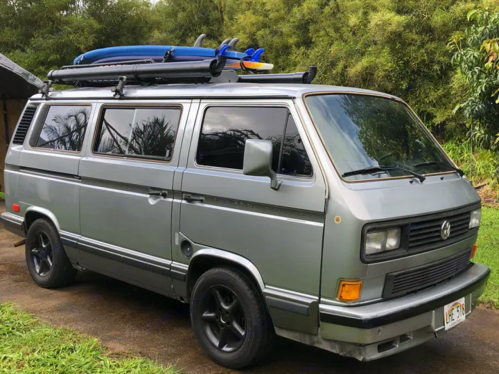 Silver classic camper van with surfboards on roof, perfect for an rv rental adventure.. VW Wolfsburg 1988
