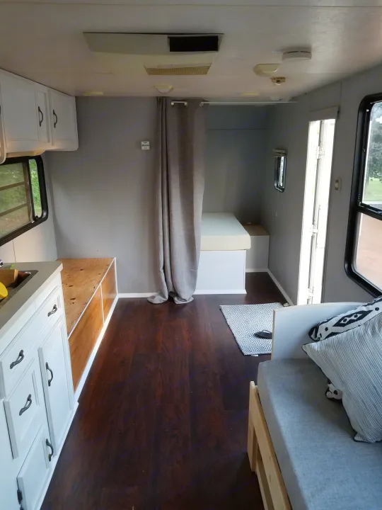 The updated memory foam full bed and sitting area next to sink. Coachmen Futura 1999