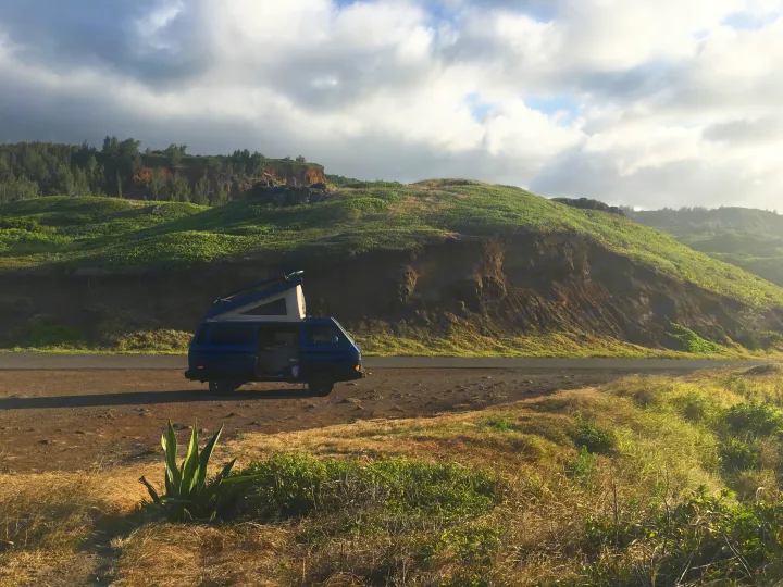Blue camper van parked for a scenic road trip. Explore nature with an RV rental adventure in hilly landscapes.. VW Westfalia 1990