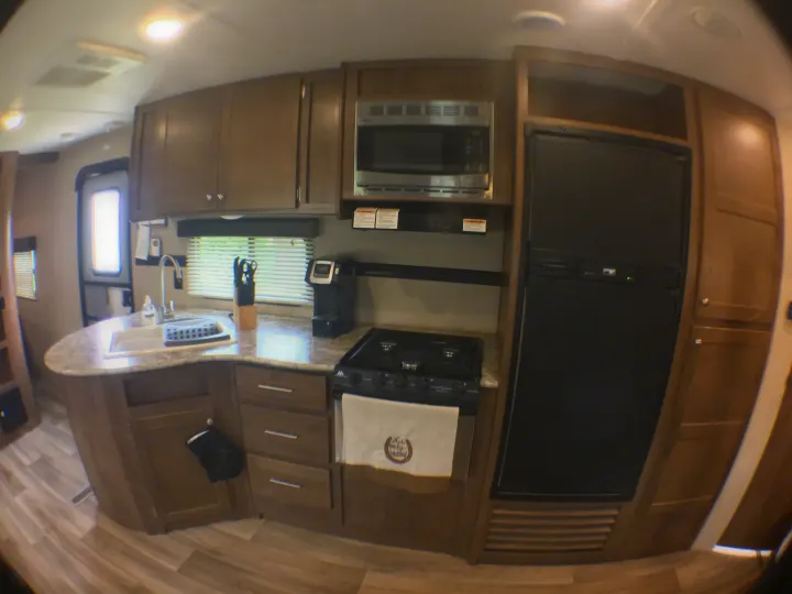 RV rental interior: A bright, well-appointed kitchen with sink, microwave, stove, and refrigerator.. Dutchmen Aspen Trail 2018