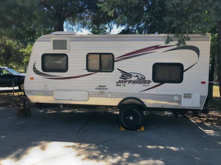 This Jayco Jay Flight SLX Baja Edition RV rental is parked on a concrete pad, ready for travel or recreation.. Jayco Jay Flight SLX 2015