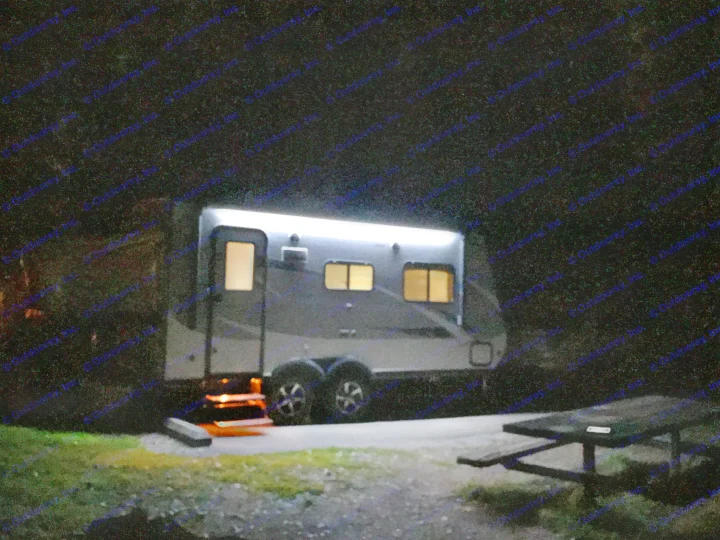 Cozy rv rental at night: A brightly lit camper glows in the dark, with a picnic table nearby at a peaceful campsite.. Jayco Jay Feather 2017