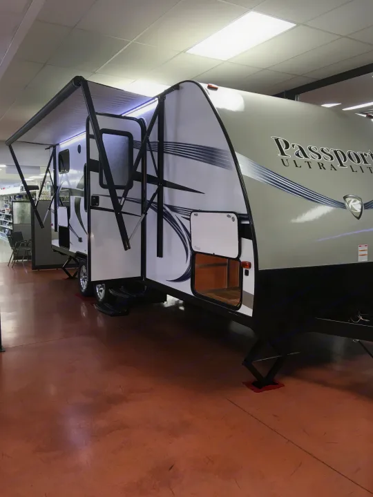 This white and gray Passport travel trailer, with an extended awning, is a prime RV rental choice.. Keystone Passport 2017