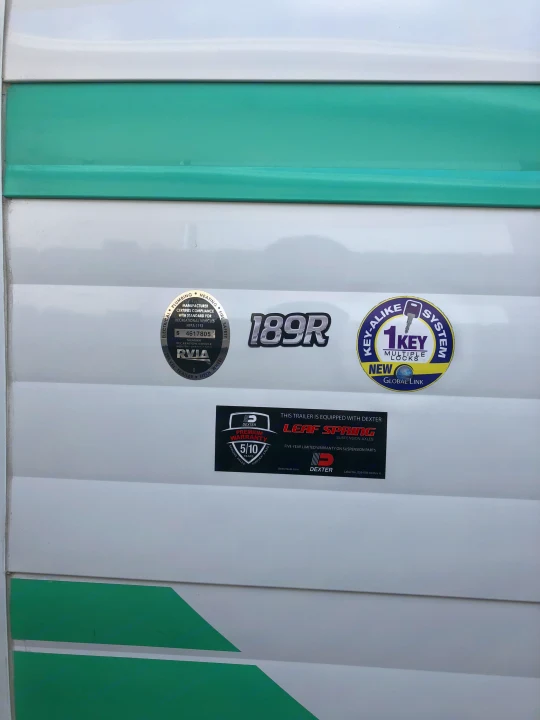 RV rental exterior showing "189R" model, RVIA, Key-Alike, and Dexter axle details on a white and green striped panel.. Riverside Rv 189R Retro 2018