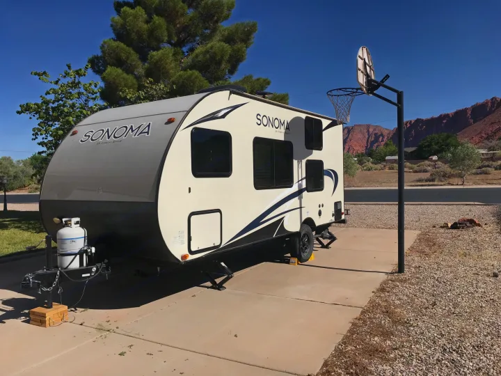 RV rental: Sonoma travel trailer parked on a driveway with red rock mountains and a basketball hoop in the background.. Forest River Forester 2017