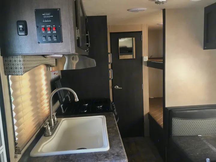 Experience this RV rental's interior: well-equipped kitchen, control panel, bunk beds, and cozy dinette area.. Forest River Forester 2017