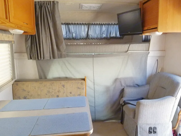 Above the cab sleeping area for 2 people. TV with DVD player. 
Privacy curtain for the sleep area.. Winnebego Mighty Minnie Winnie 2003