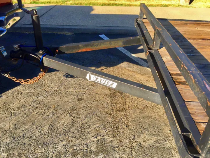 View of a trailer hitch, safety chains, and the tongue of an Eagle trailer. Perfect for RV rental extra cargo hauling. On pavement.. Eagle 33305 2003