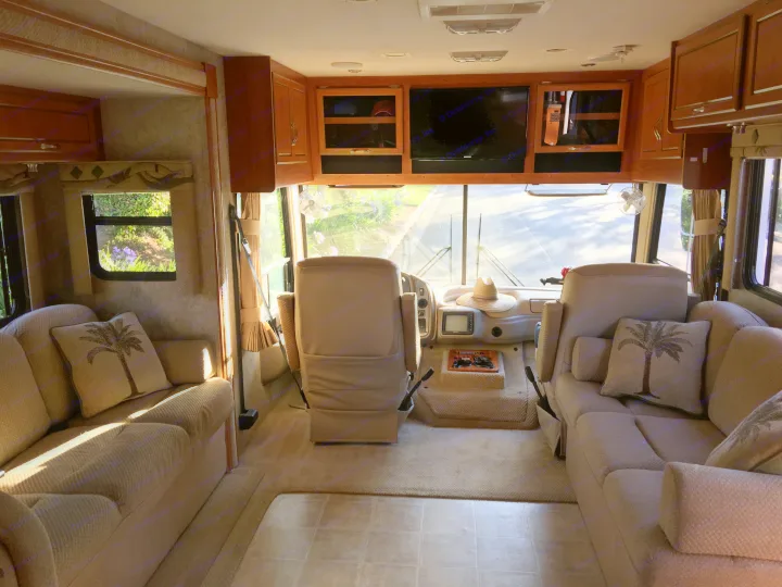 Cozy RV rental interior: living area with sofas & TV, plus front cockpit. Perfect for travel adventures!. National Surf Side 2006