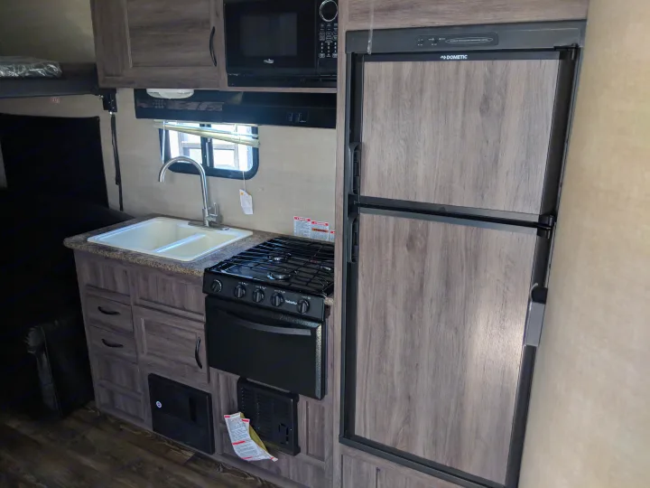 Tour your next rv rental: a well-equipped kitchen with a double sink, gas stove, microwave, & refrigerator.. Pacific Coachworks Blaze'N 2019