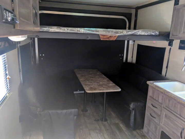 An RV rental's versatile interior with fold-down bunks, convertible dinette, and compact kitchen area.. Pacific Coachworks Blaze'N 2019