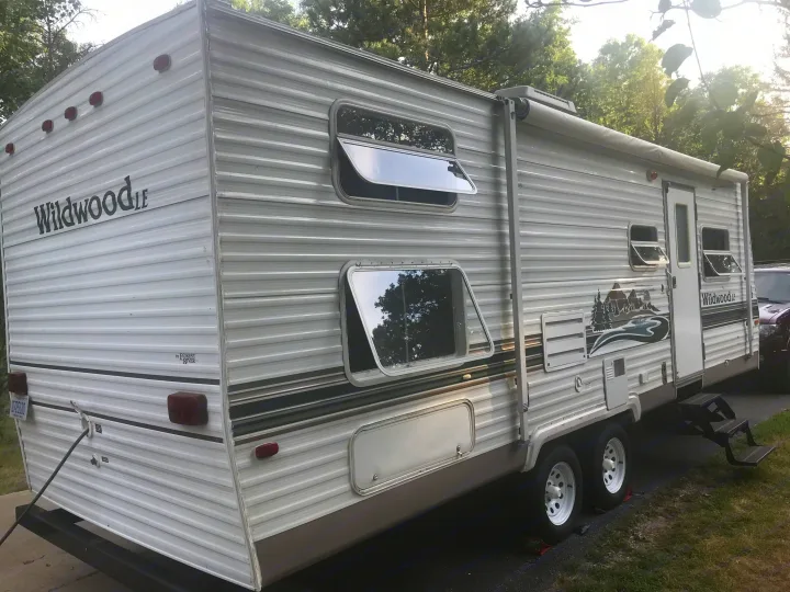 Explore the outdoors with this white Wildwood LE travel trailer. Great for an RV rental or camping trip.. Forest River Wildwood 2005