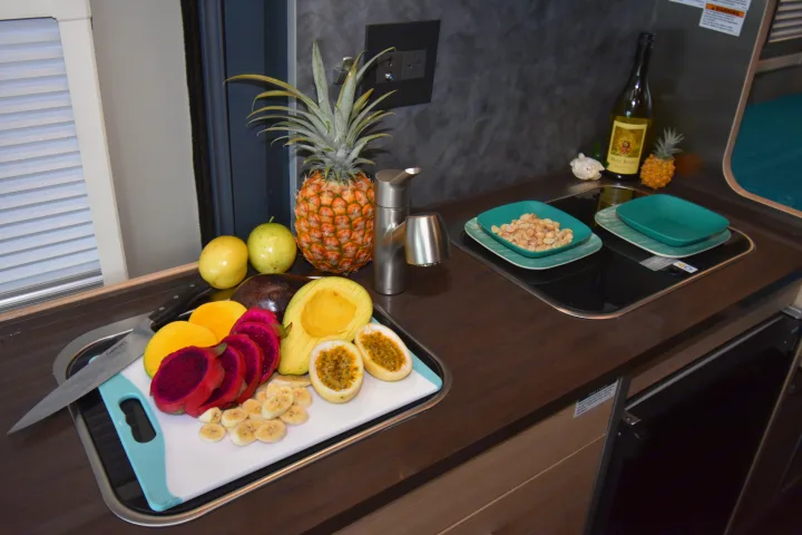 Colorful fresh fruit, nuts, and wine in a compact RV rental kitchen, perfect for healthy travel meals.. Hymer Aktiv 2018