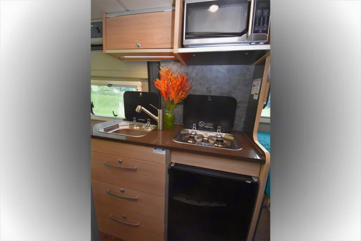 Experience home comforts in your rv rental with this efficient kitchen: sink, stove, microwave, and fridge, ready for camper meals.. Hymer Aktiv 2018