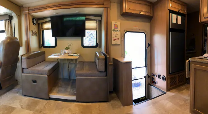 Spacious RV rental interior with dinette, TV, refrigerator, and main entry door.. Thor Windsport 2018