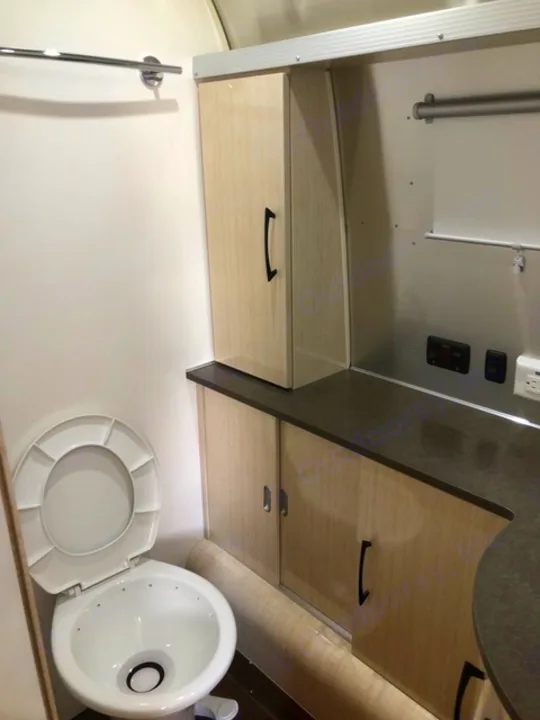 Modern RV rental interior: clean bathroom with toilet, light wood cabinetry, and sleek design.. Airstream Flying Cloud 2017