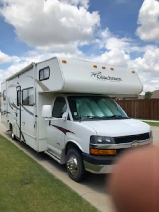 A white Coachmen Class C RV, parked outside on a sunny day. Ideal for an RV rental, travel, or camping getaway!. Coachmen Freelander 2013