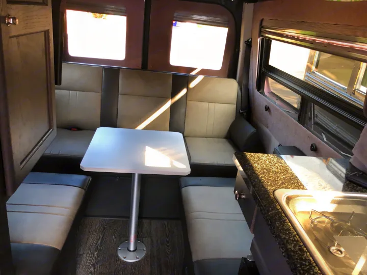 Rear with table set up. Sofa is electric and flattens into 2 twin beds or one full/queen bed with with adapter piece added n (stores under seat under the TV). Roadtrek Roadtrek Class B 2015