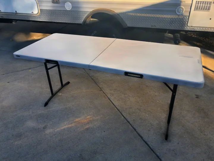 White folding table positioned on concrete next to an RV rental. Perfect for expanding your outdoor space while camping.. Jayco Jay Flight SLX 2015