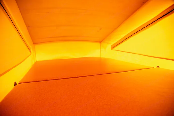 Explore comfortably in this RV rental's pop-top sleeping area, featuring an orange bed and yellow fabric walls.. Volkswagen westfalia 1979