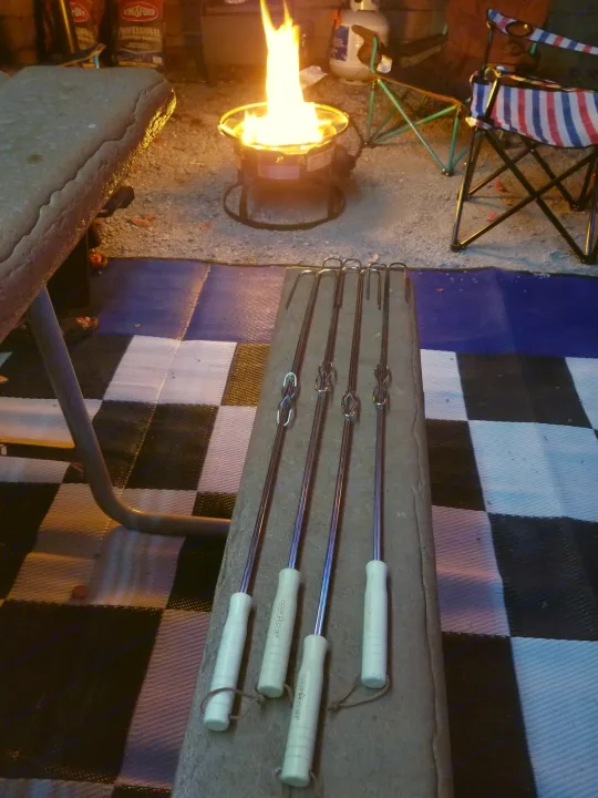 Portable fire pit and roasting sticks at a cozy RV rental campsite, perfect for evening s'mores.. Other Other 2019