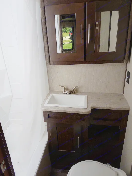 RV rental: Compact bathroom with dark wood cabinets, small sink, shower base, and toilet.. Cruiser Rv Corp Radiance 2019