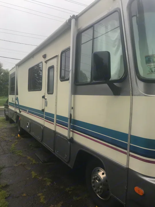 This Class A RV rental features a cream and grey exterior with blue and purple stripes. Ready for your next adventure!. Gulf Stream Sun Stream 1995