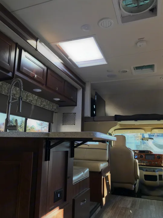 Spacious RV rental interior showcasing a modern kitchen, dining area, overhead bunk, and driver's cabin.. Forester 3271 LE 2018