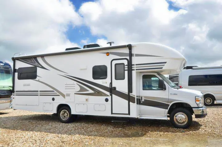 White Class C RV rental motorhome with modern gray graphics parked on a gravel lot, ready for your next adventure.. Other Other 2019