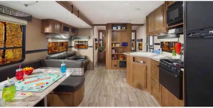 View from back of the trailer (bathroom) to the front looking towards the master. There is a lot of floor room to easily get around company. Kitchenette seats 6-8.  Couch seats 3 and sleeps 2 adults comfortably. Comes with nice folding coffee table. Not shown: Television is hung to the left of sofa in that void space you see. There is another Televsion in the master.. Dutchmen Aspen Trail 2750BHS 2017
