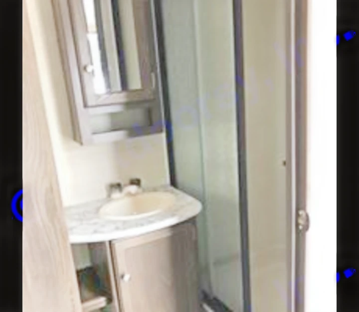 Compact RV rental bathroom features a sink, mirror, vanity, and glass shower. Ideal for travel adventures.. Keystone Bullet 2018