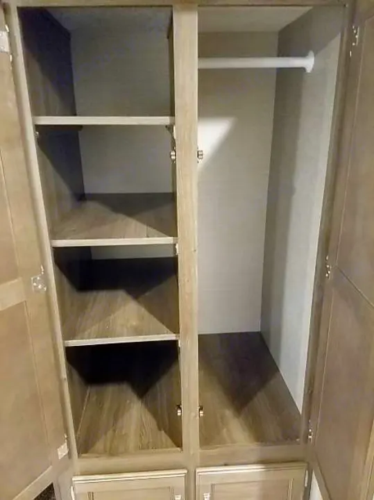 RV rental: Open wardrobe with multiple shelves on the left and a clothing rod on the right, providing versatile storage.. Keystone Bullet 2018