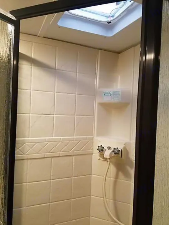 RV rental bathroom shower with molded walls, a skylight, and compact fixtures for travelers.. Keystone Bullet 2018