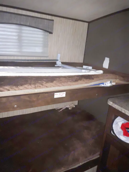Inside an RV rental, showing the bunk beds. The top bunk's frame clearly displays a 275 lbs max weight limit sticker for safety.. Heartland Sundance 2018
