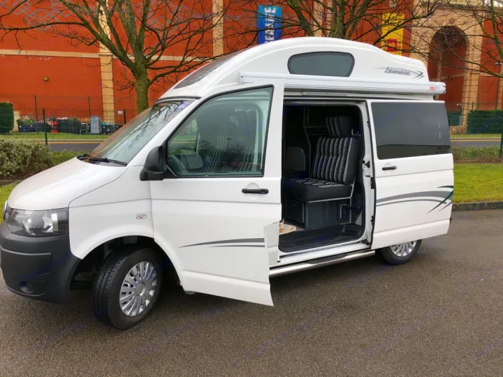 White campervan with open side door, showing interior seats & pop-top roof. Ideal for your next rv rental adventure.. Volkswagen T5 Vivante 2015
