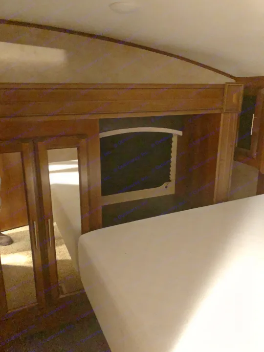 Experience comfort in this RV rental bedroom: cozy bed, overhead storage, and mirrored closet.. Jayco 27.5 BHS 2018