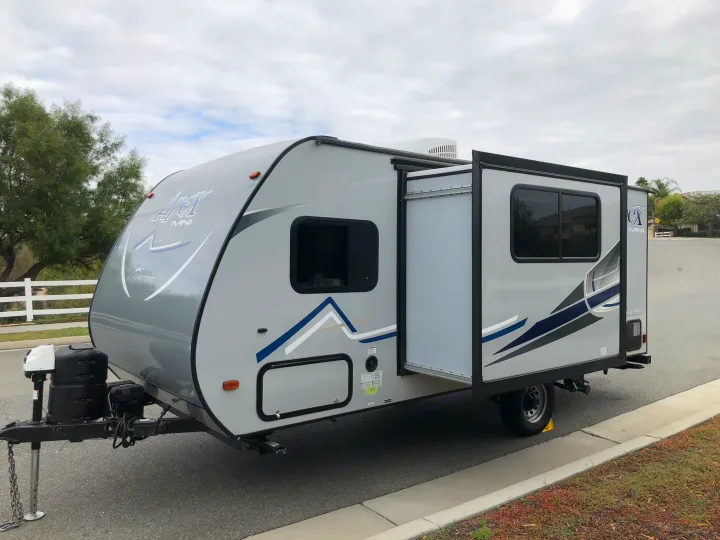 Modern grey Apex Nano travel trailer, an ideal RV rental with its slide-out open, ready for your next camping adventure.. Coachmen Apex 2018