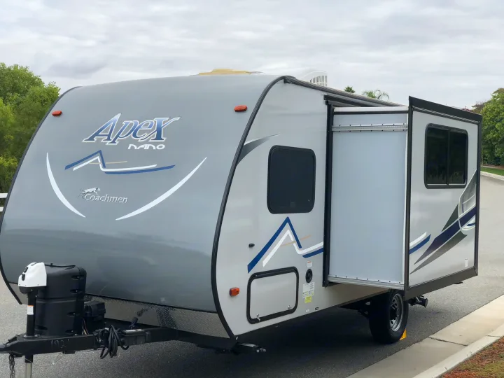 Explore in this modern grey Apex Nano travel trailer, featuring a slide-out, available for RV rental.. Coachmen Apex 2018