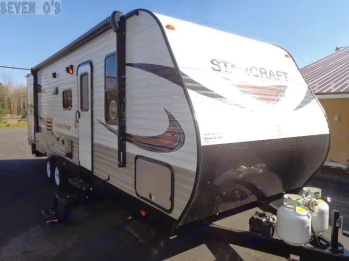 This Starcraft travel trailer RV rental, a modern camper with an awning, steps, and propane tanks, is ready for your trip.. Starcraft Autumn Ridge 27BHS 2018