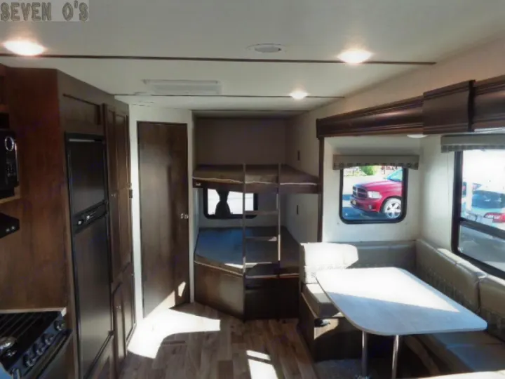 Modern RV rental interior with a kitchen, dining booth, and bunk beds. Perfect for family road trips and comfortable stays.. Starcraft Autumn Ridge 27BHS 2018