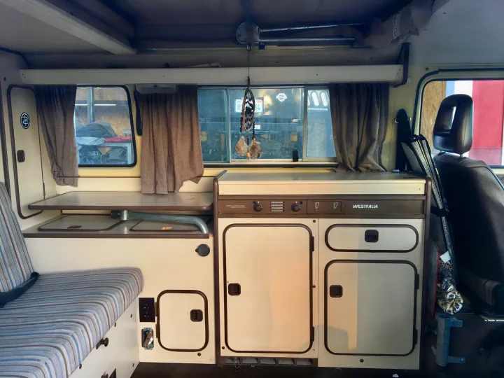Detailed interior of a Westfalia camper van, showing compact kitchen, seating, and storage. Perfect for an rv rental adventure.. Volkswagen Vanagon 1984