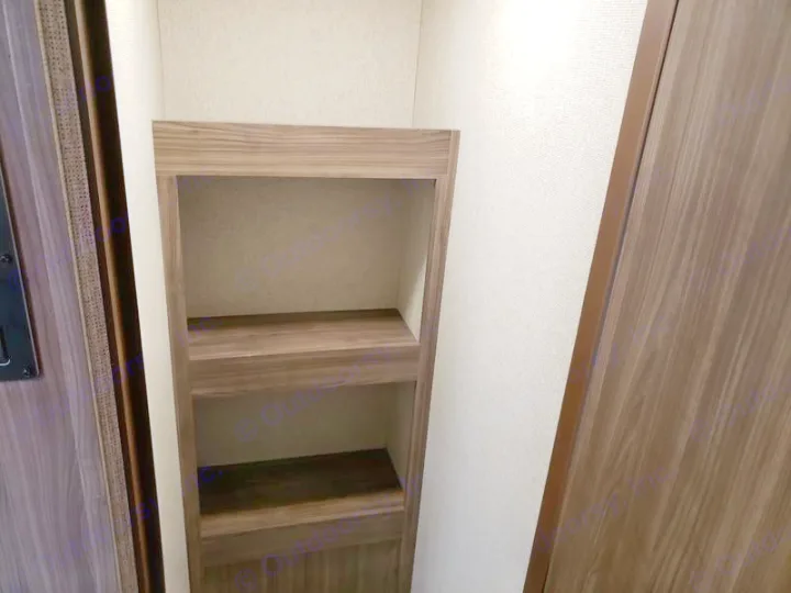 RV rental interior: Built-in wooden shelves offer practical storage in a compact space with textured walls and wood trim.. Coachmen Apex 265rbss 2019