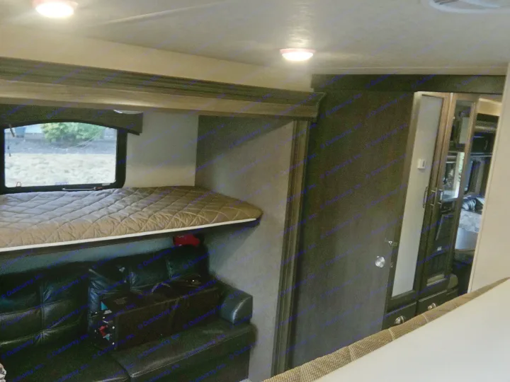 An RV rental interior: elevated sleeping area with quilted mattress, window view, and glowing floor lights. Cozy night scene.. Forest River Evo 2016