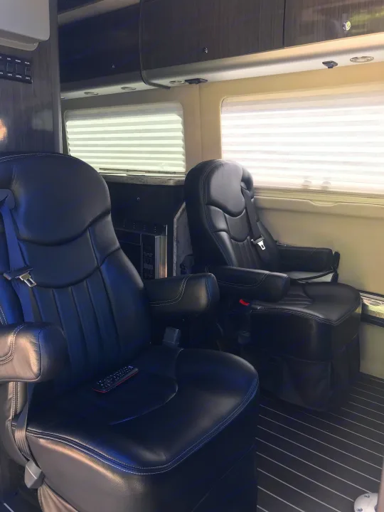 This rv rental features a luxurious interior with black leather captain's chairs, window blinds, and a microwave.. Airstream Interstate 2014