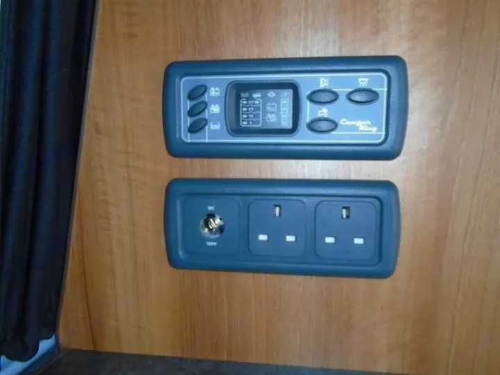 RV rental interior features: a Camper King control panel and integrated 12V plus UK AC power outlets.. Volkswagen T5 premium camper 2012