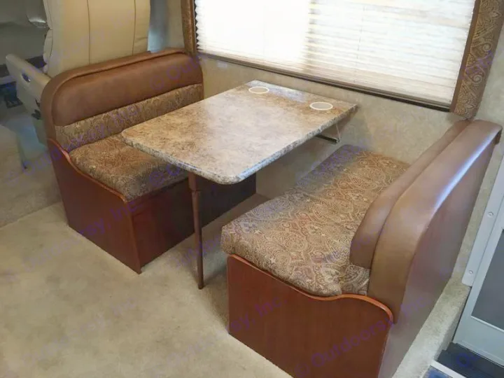 RV rental interior: Cozy dinette with booth seating & table, perfect for meals on the go.. Ford Hurricane 2011