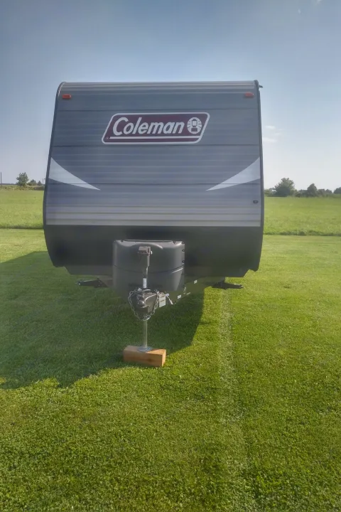 Front view of a Coleman travel trailer parked on green grass. Perfect for an RV rental adventure!. Coleman 244BH 2017
