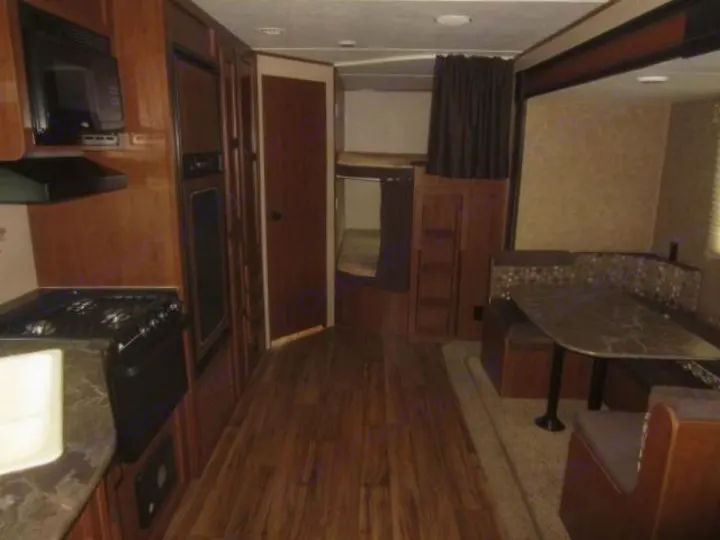 RV rental interior featuring a well-equipped kitchen with microwave/stove/fridge, a dining booth, and bunk beds.. Jay Flight 287 BHSW 2016