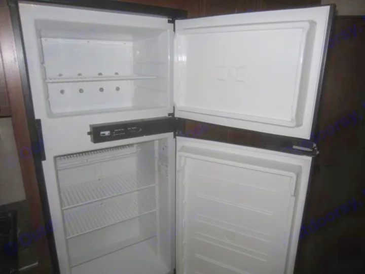 Open RV rental refrigerator, empty inside. Features upper freezer and lower fridge with wire shelves, ready for your adventure.. Jay Flight 287 BHSW 2016